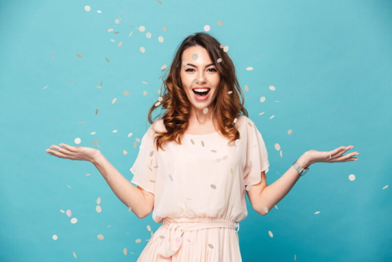 Smiling woman throwing confetti