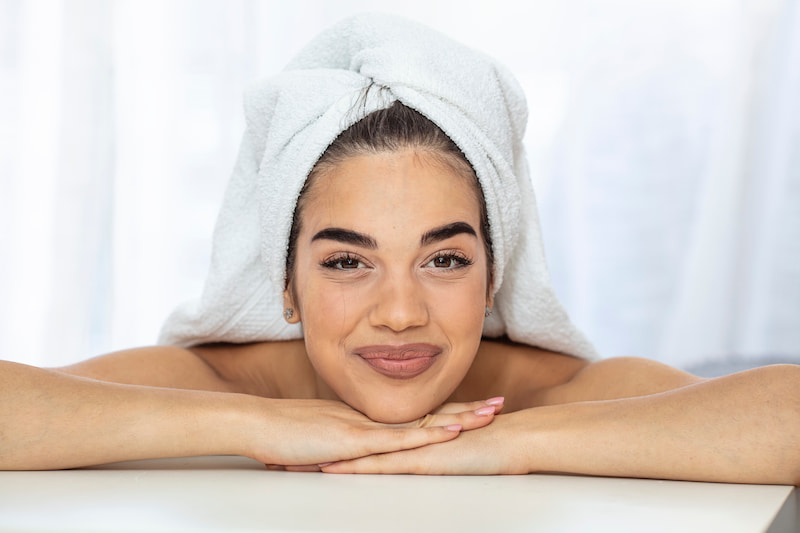 Woman with spa towel on head and glowing skin